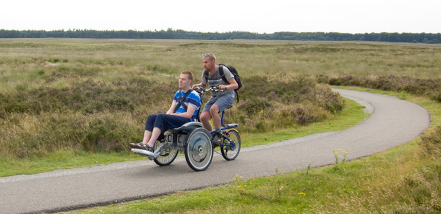 Taking a wheelchair user for a ride at Hoge Veluwe National Park. Photo © Holland-Cycling.com